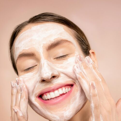 Girl washing face with a cleanser product